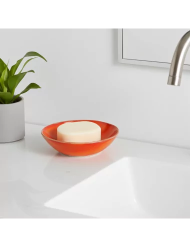 Seifenschale Ton rund orange neben weissem Lavabo