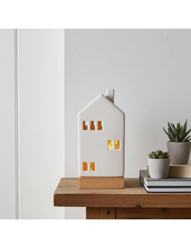 Lichthaus - Teelicht Haus - Dekoration Weihnachten - weiss-glänzend - 22,5 cm auf Ablage neben Büchern beleuchtet